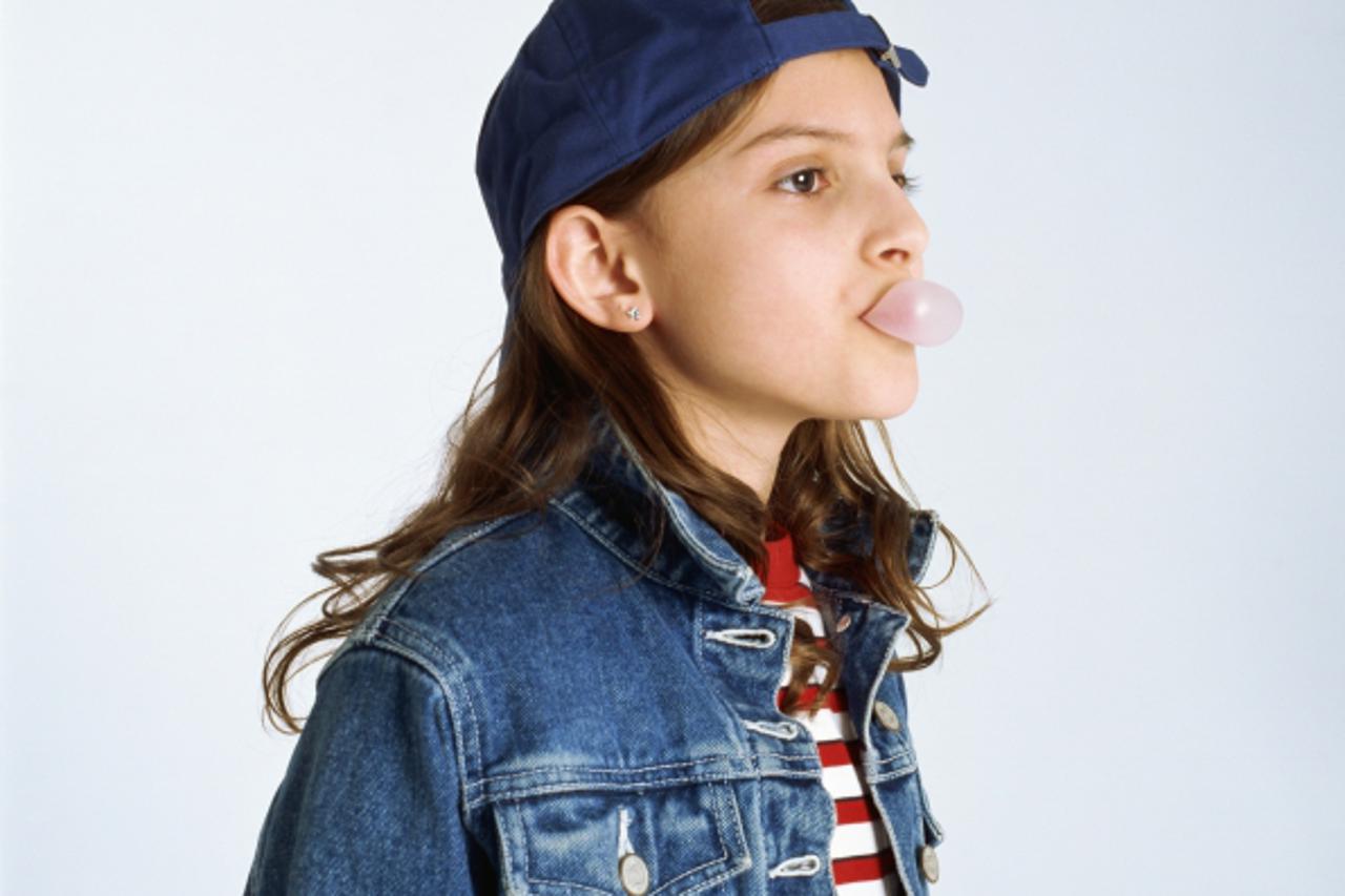 'Tween girl blowing bubble'