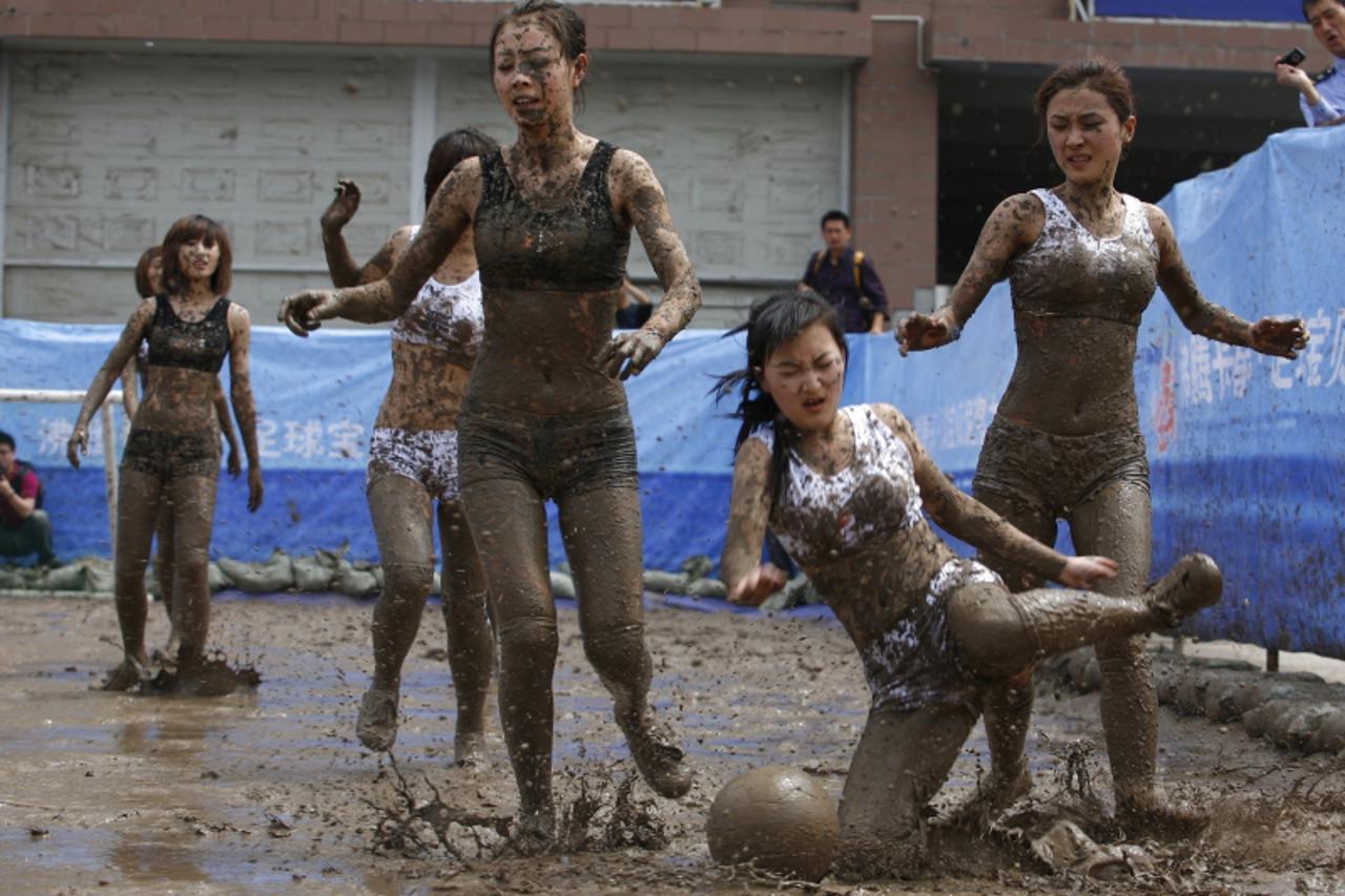 'A group of Chinese women cheer as they play a mud football game during a promotion for the upcoming World Cup football, in Changchun, northeast China\'s Jilin province on May 30, 2010.  Chinese socce