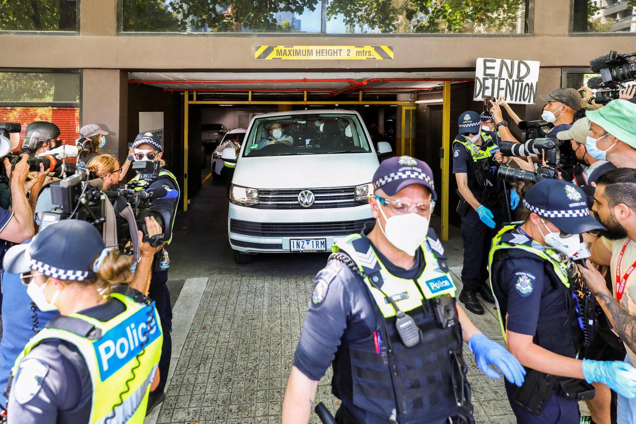 Media surround a vehicle at the facility where Novak Djokovic has been held in Melbourne