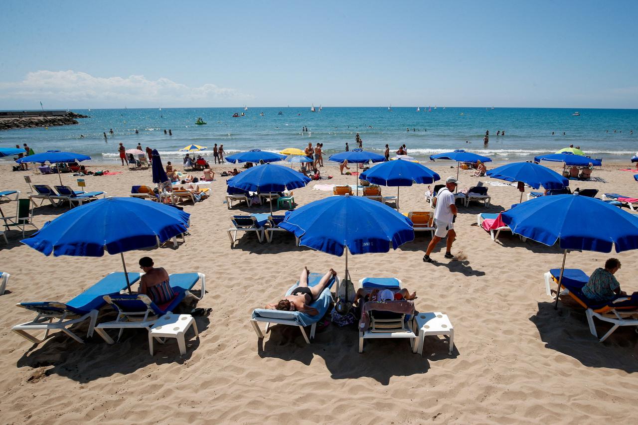 FILE PHOTO: People cool off at a beach in Sitges town