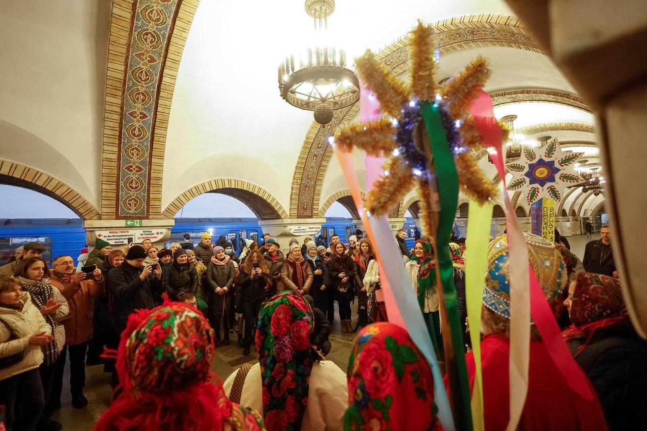 Ukrainians sing Christmas carols amid an air raid alarm, inside a metro station in Kyiv