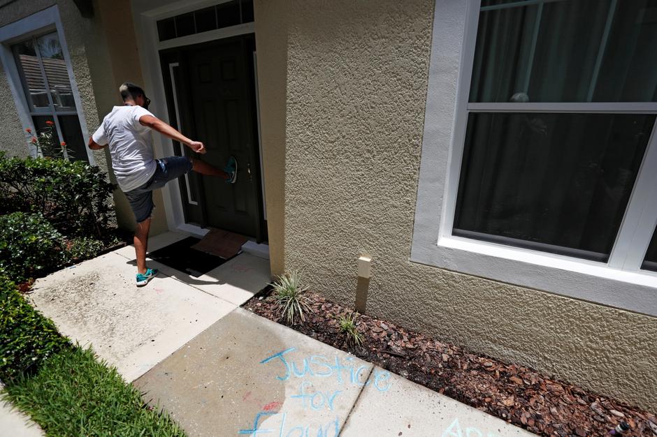 A protesters kicks the door of the Florida home of former Minneapolis police officer Derek Chauvin, in Orlando