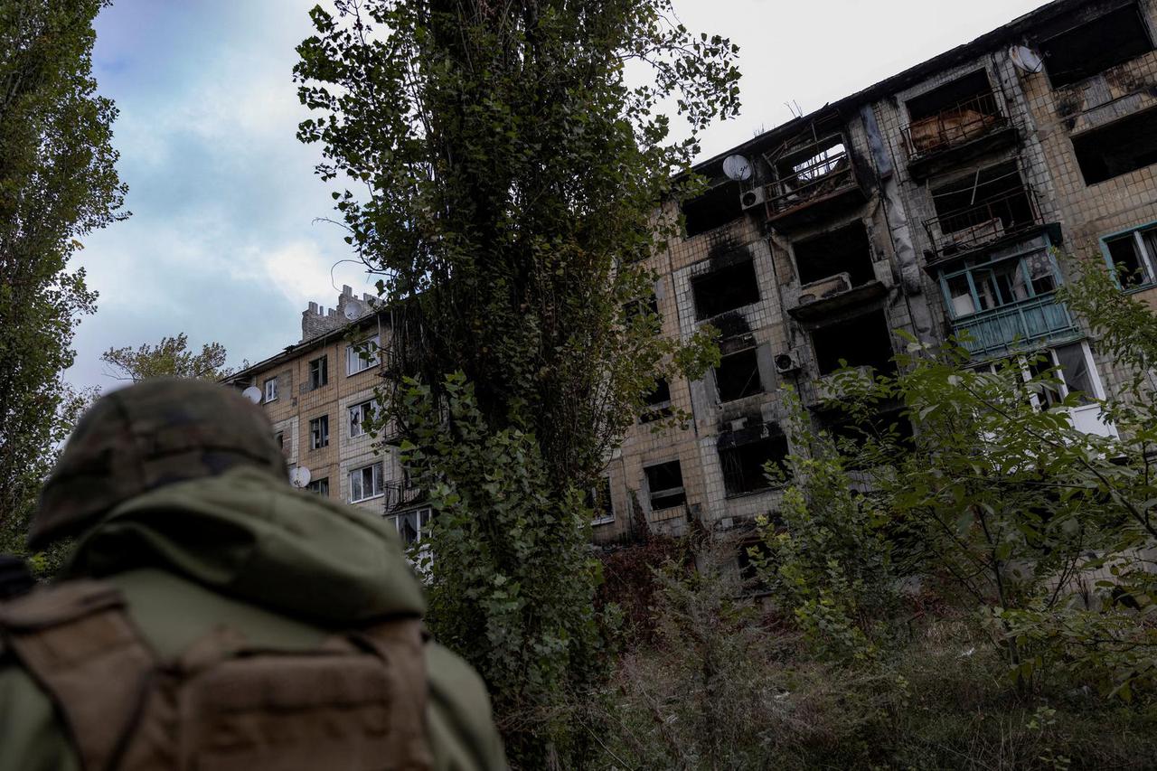 FILE PHOTO: Police officer walks near a damaged residential building in Avdiivka