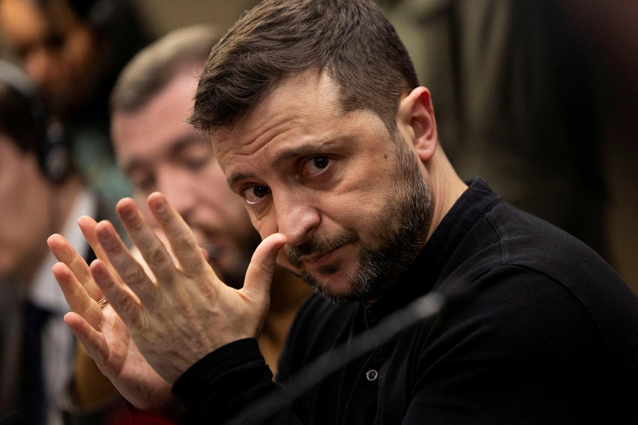 Ukrainian President Volodymyr Zelenskiy gestures during a meeting with members of the media on the outskirts of London