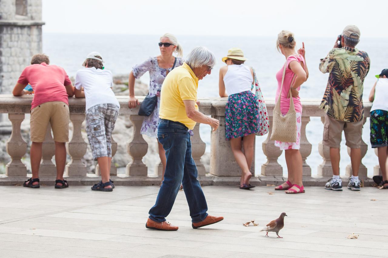 10.08.2013., Dubrovnik - Bernie Ecclestone sa suprugom Fabianom Flosi i povecim drustvom prosetao gradom, popio kavu u Festivala i rucao u Nautici. Bernie, ocito fasciniran golubovima proveo je dobrih 10-ak minuta pokusavajuci uloviti kojeg. Photo: Grgo J