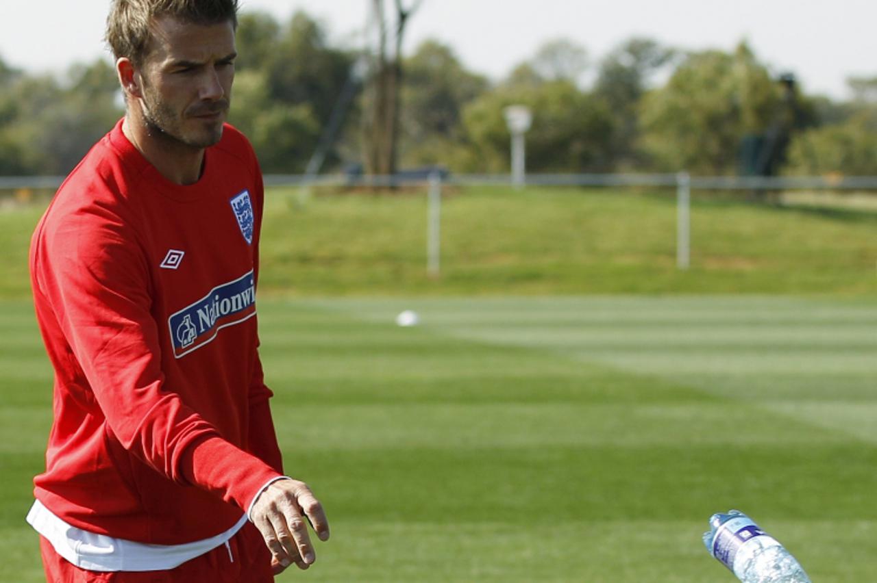 'England\'s David Beckham throws a bottle during a World Cup soccer training session at the Royal Bafokeng Sports Campus near Rustenburg, June 4, 2010.   REUTERS/Darren Staples   (SOUTH AFRICA - Tags: