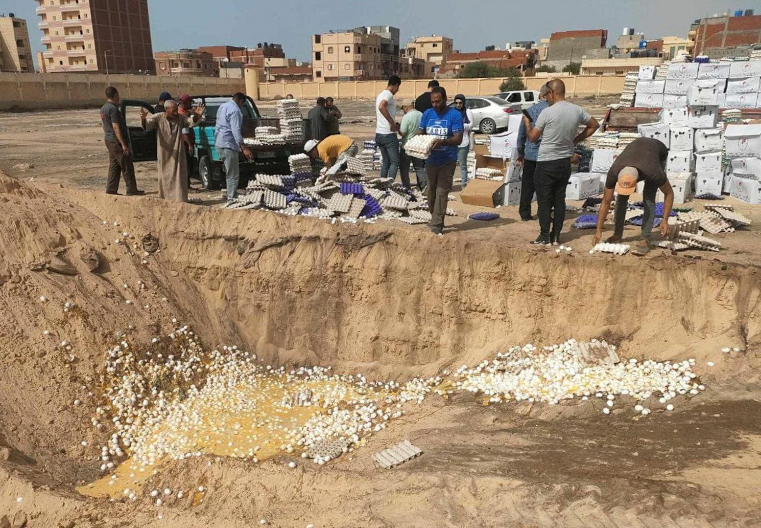 People dispose of rotten eggs, part of aid packages for Gaza that had gone bad as Rafah crossing remains closed, amid the ongoing conflict between Israel and the Palestinian Islamist group Hamas, in Rafah, Egypt, May 22, 2024. REUTERS/Stringer Photo: Stringer/REUTERS