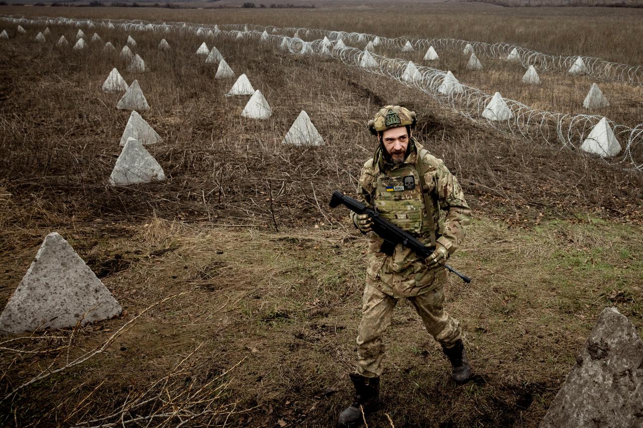 Ukrainian serviceman carries shells for a self-propelled howitzer at a position in a front line near the town of Bakhmut