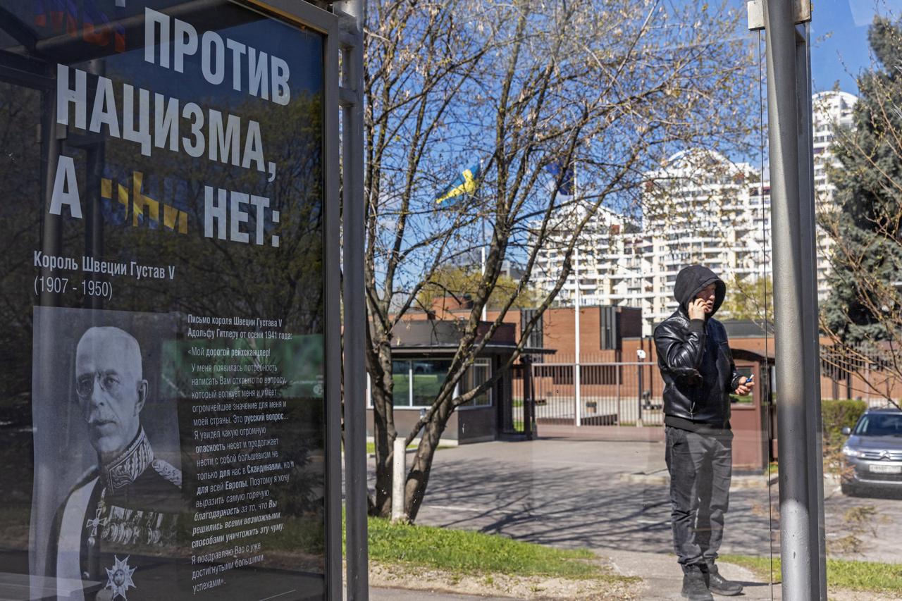 A poster reading "We are against Nazism, they are not" is installed at a bus stop in Moscow
