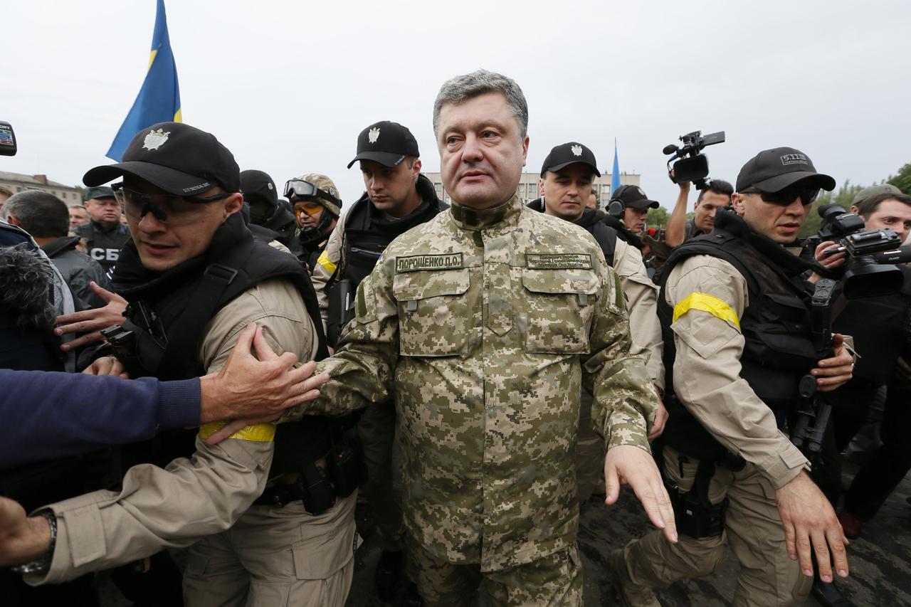 Ukrainian President Petro Poroshenko (C) makes his way during a meeting with local residents in the eastern Ukrainian town of Slaviansk, July 8, 2014. Ukraine's government kept up military pressure against pro-Russian rebels on Tuesday, threatening them w