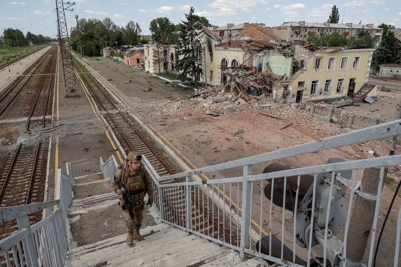 A Ukrainian serviceman walks near a railway station damaged by Russian military strikes in the frontline town of Kostyantynivka