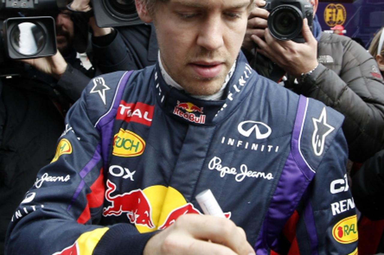 'Red Bull Formula One driver Sebastian Vettel of Germany signs an autograph in the paddock during a training session at the Circuit de Catalunya racetrack in Montmelo, near Barcelona, February 19, 201