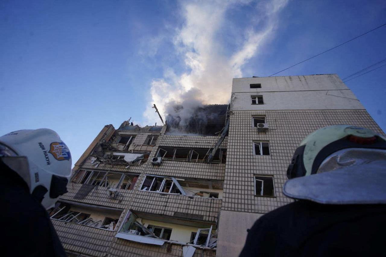 Rescuers work next to a residential building damaged by shelling in Kyiv