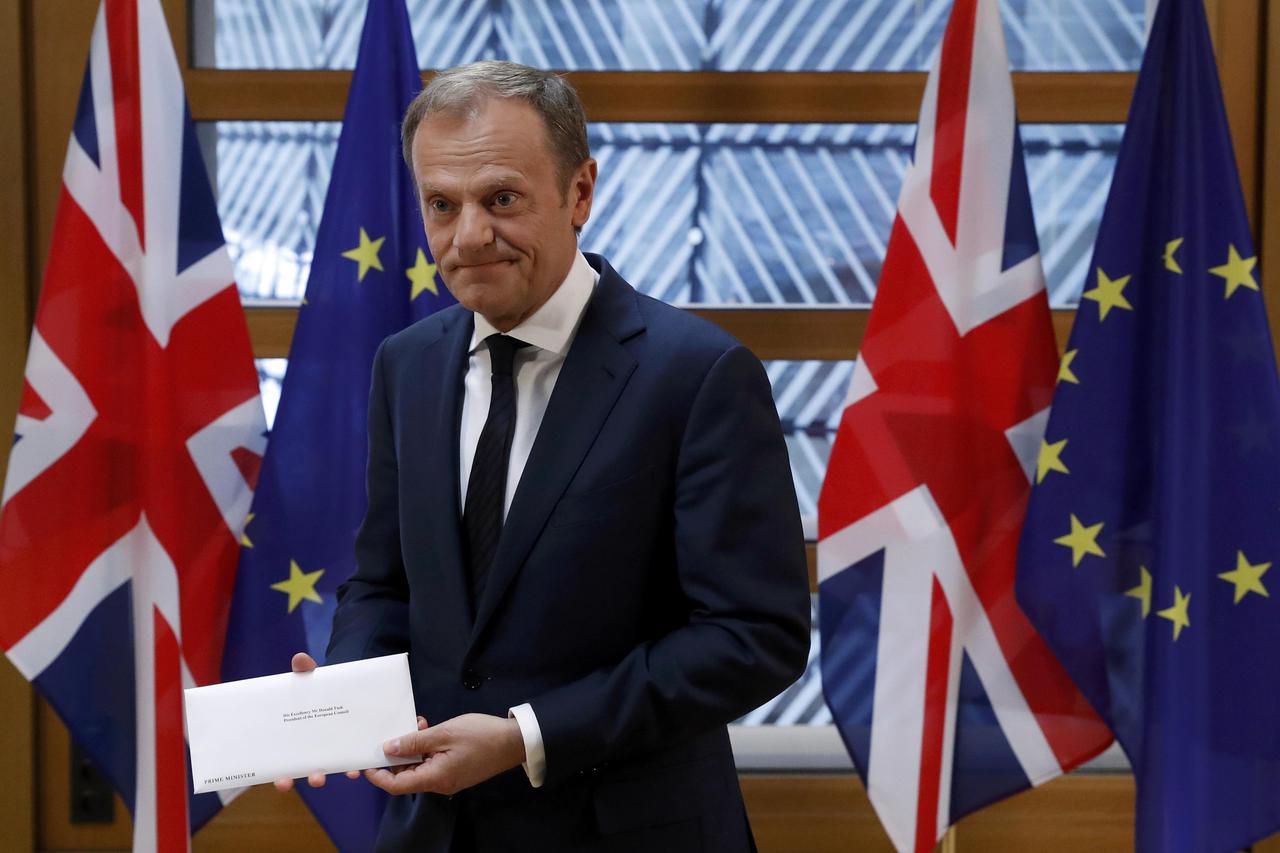 EU Council President Donald Tusk holds British Prime Minister Theresa May's Brexit letter which was delivered by Britain's permanent representative to the European Union Tim Barrow (not pictured) that gives notice of the UK's intention to leave the bloc u