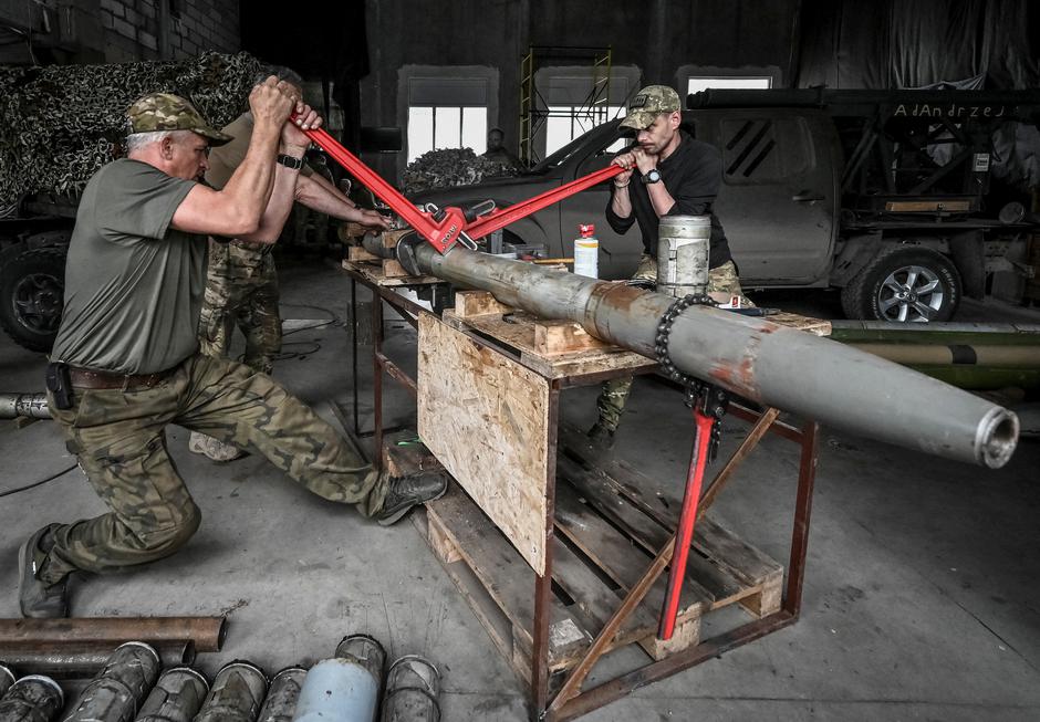 Members of company tactical group "Steppe Wolves" disassemble a shell for a BM-21 Grad multiple launch rocket system to convert it for use with a handmade small MLRS for firing toward Russian troops in Zaporizhzhia region