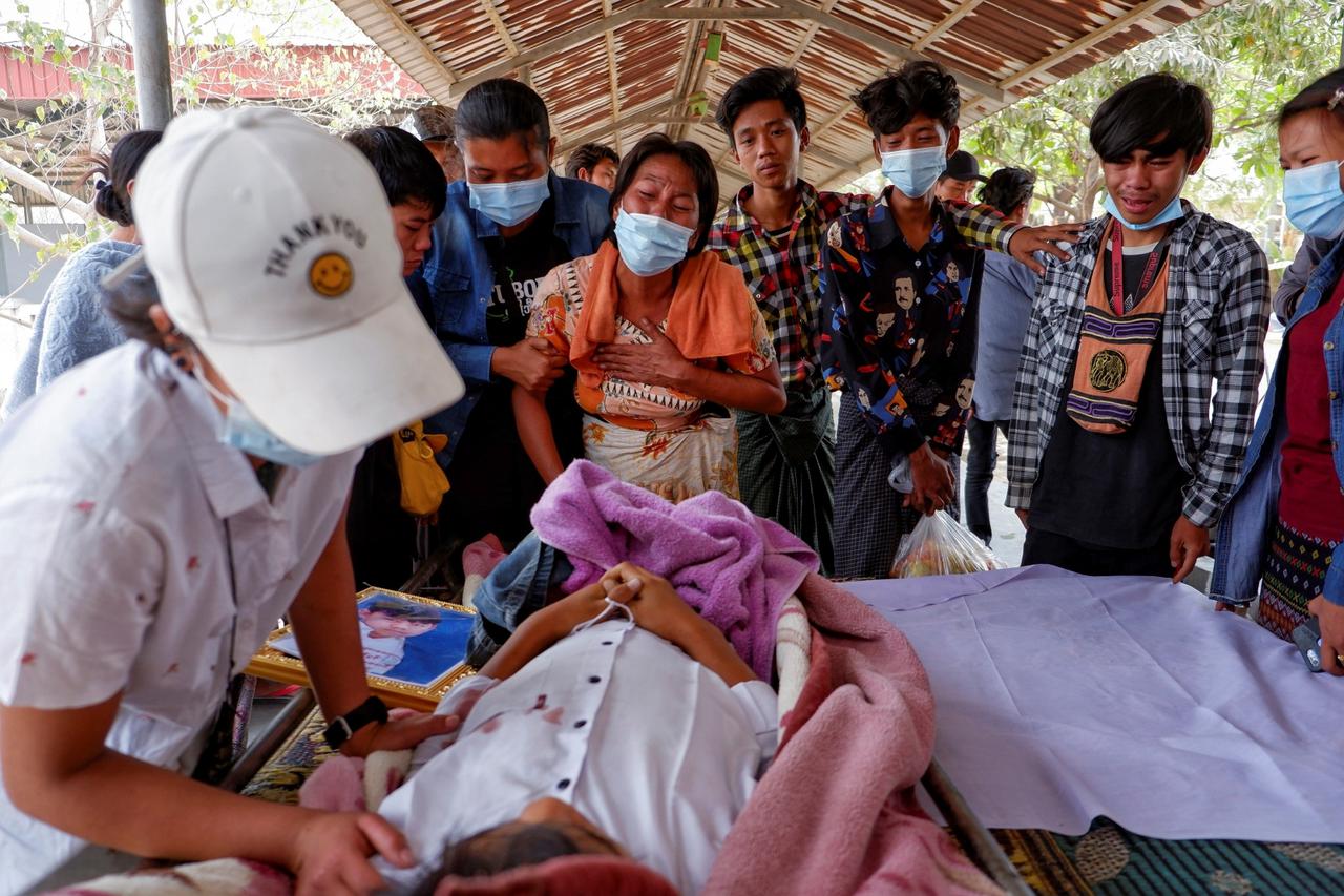 Family members cry near dead body of a teenage boy Tun Tun Aung who was shot dead by security forces in front of his home in Mandalay
