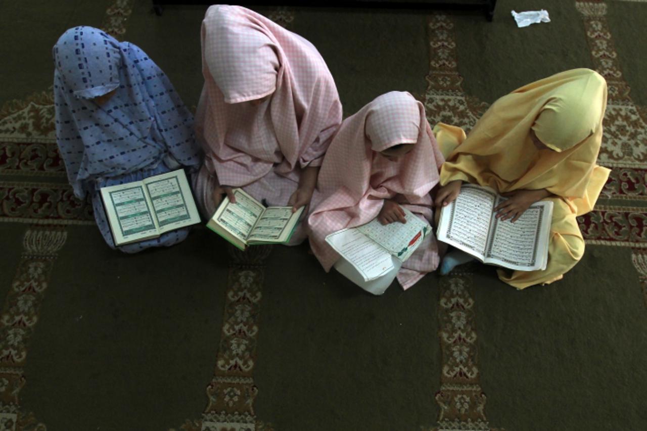 'Palestinian girls attend a class on how to read the Koran, Islam's holy book, at a camp in a local mosque in Gaza City on June 11, 2012. AFP PHOTO/MAHMUD HAMS'