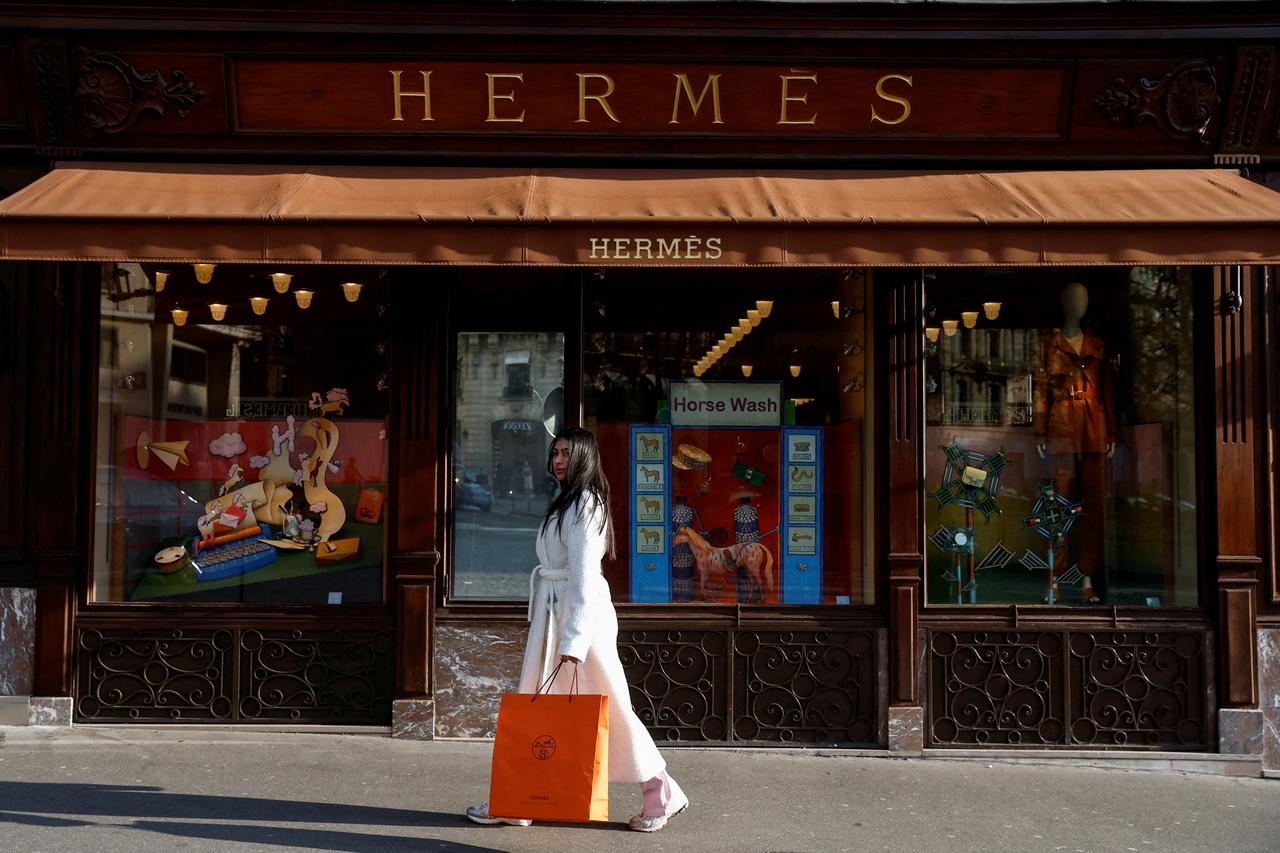 FILE PHOTO: A woman walks in front of a Hermes store in Paris