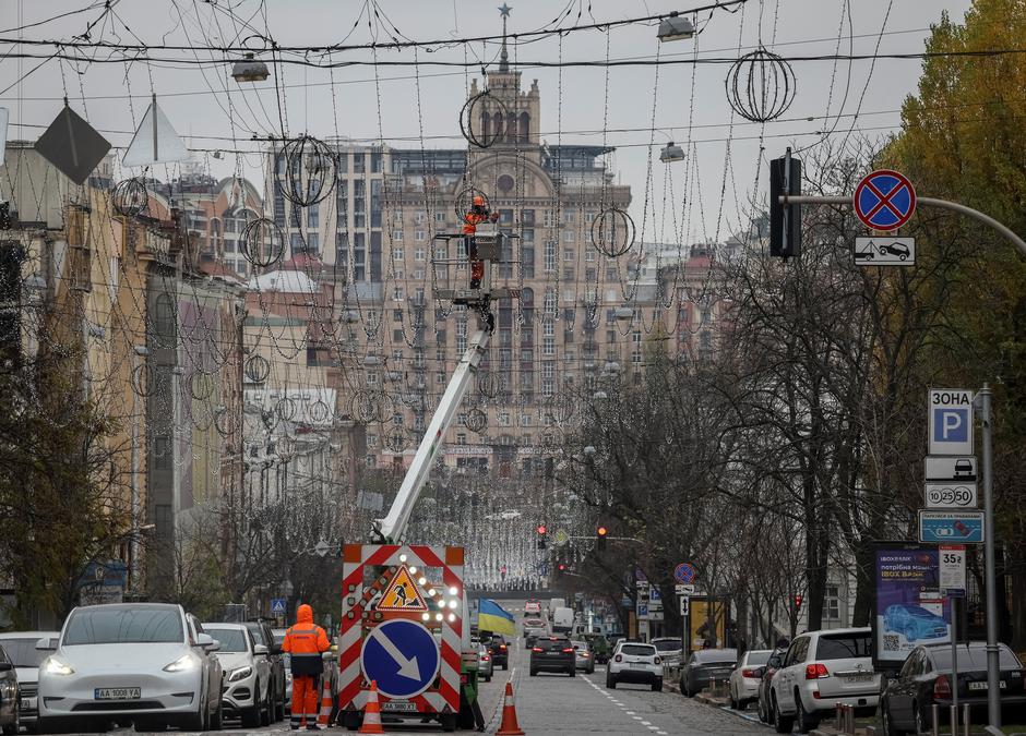 A worker installs decorative lights for the upcoming Christmas and New Year celebrations in central Kyiv