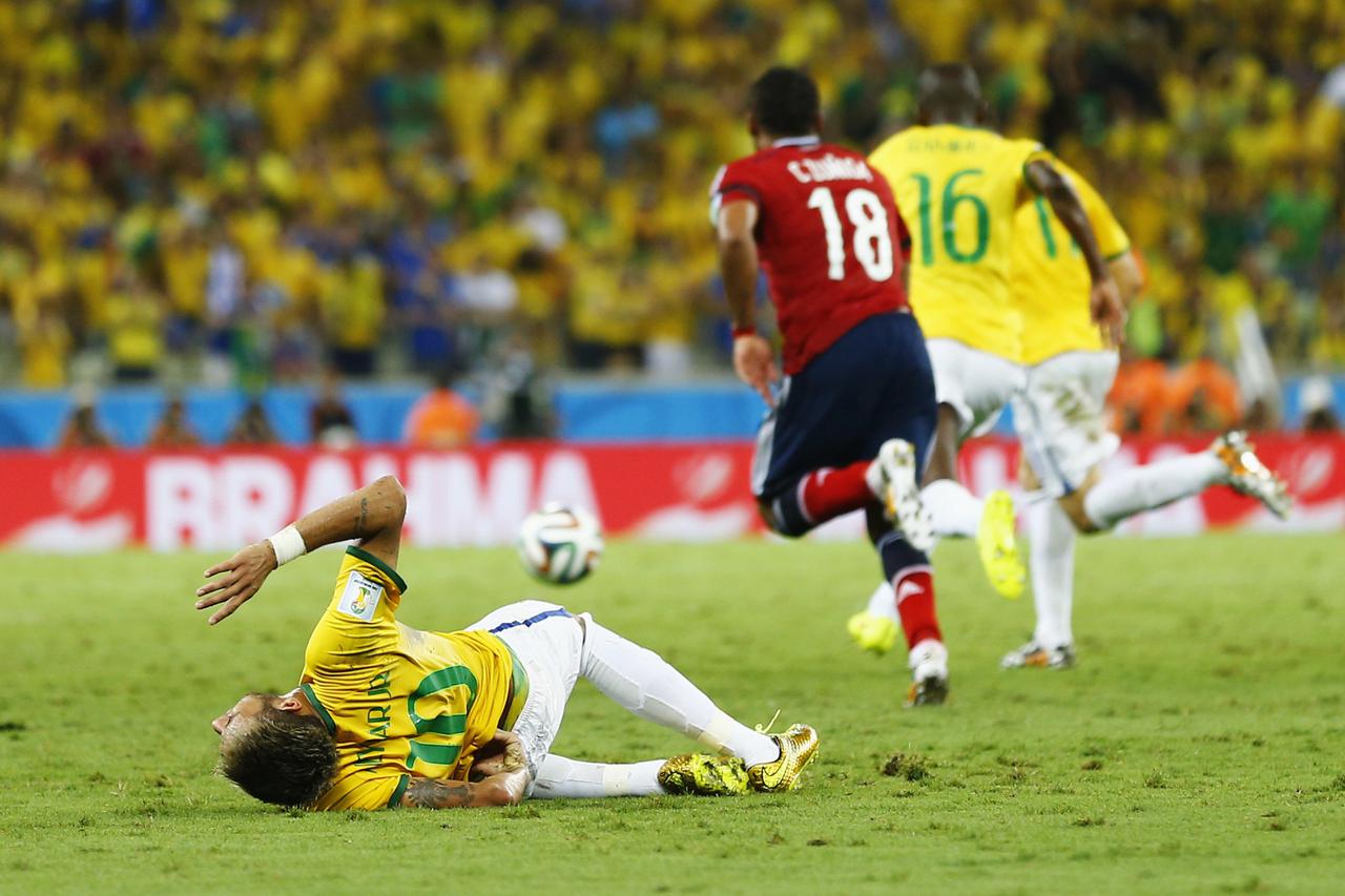 Brazil's Neymar (L) falls after being fouled by Colombia's Camilo Zuniga during their 2014 World Cup quarter-finals at the Castelao arena in Fortaleza July 4, 2014. REUTERS/Marcelo Del Pozo (BRAZIL - Tags: SPORT SOCCER WORLD CUP)