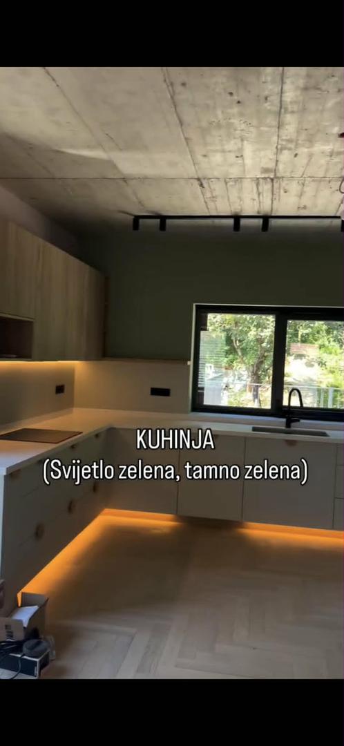 Kuhinja se u dvije nijanse zelene skladno spaja sa sirovim betonskim stropom.