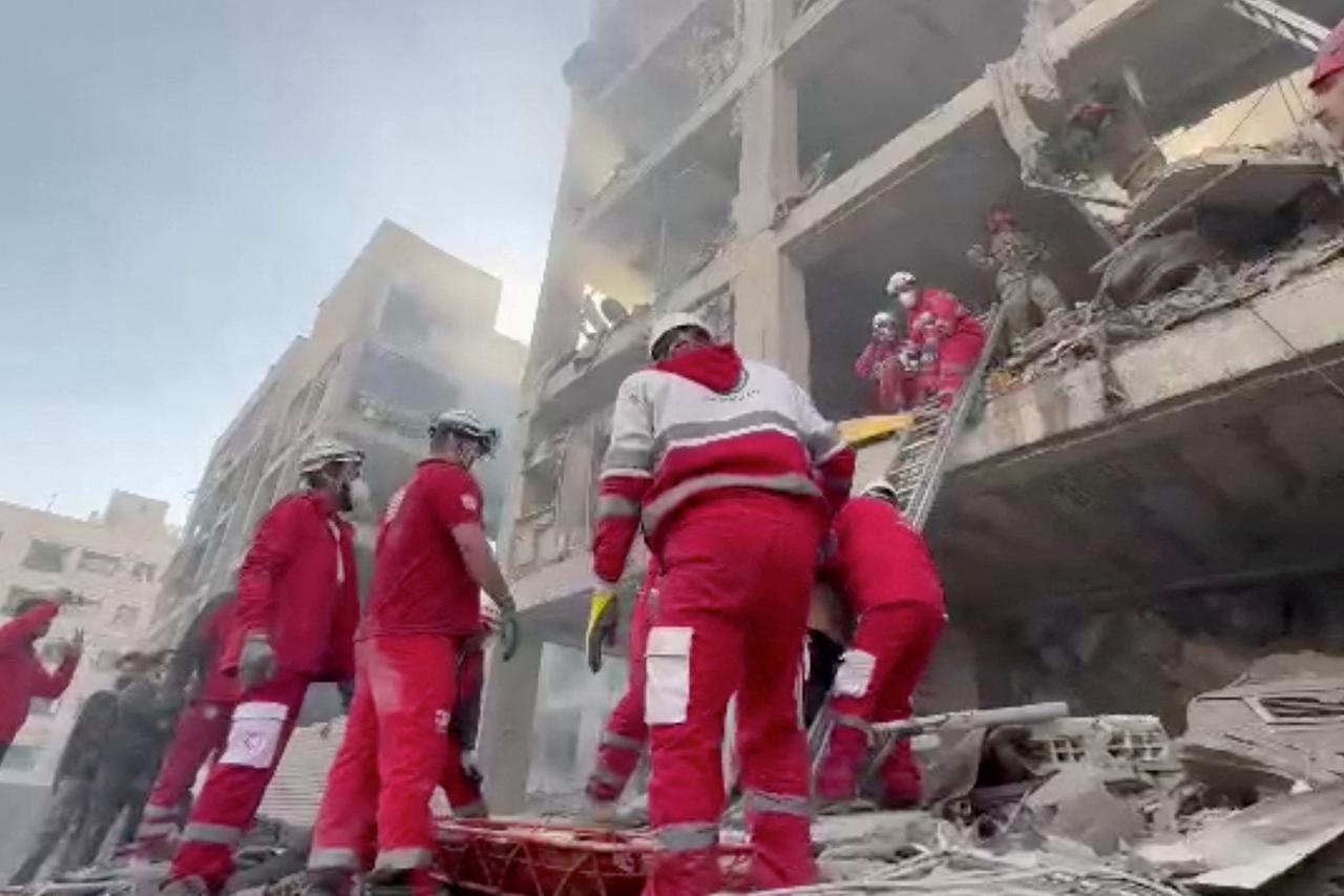 Rescuers work in the rubble of residential buildings after air strikes, in the Resalat neighborhood