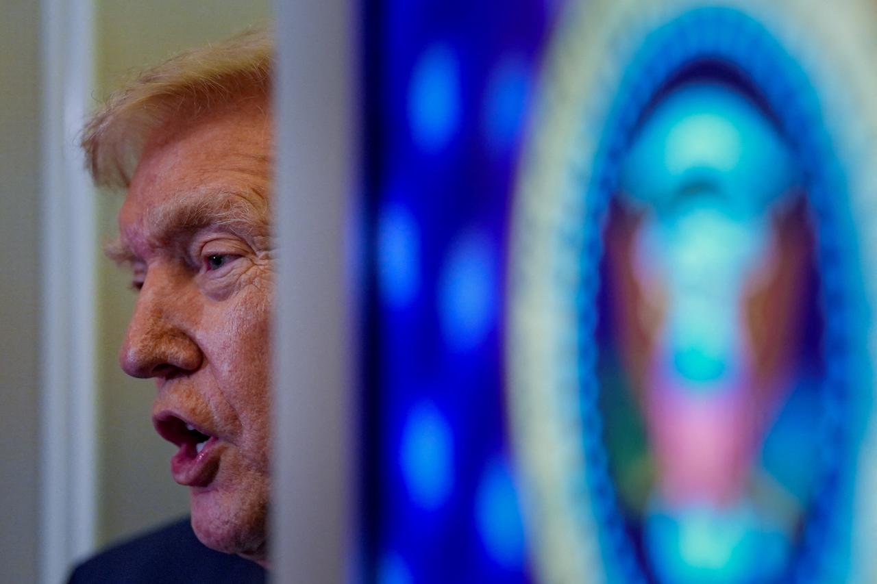 U.S. President Donald Trump speaks with members of the media on board Air Force One