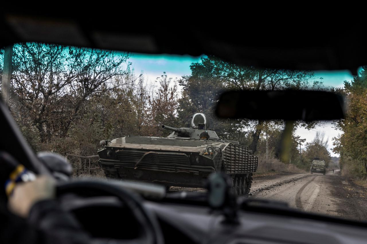 Ukrainian serviceman rides along a road in a BMP-1 armoured fighting vehicle in Avdiivka