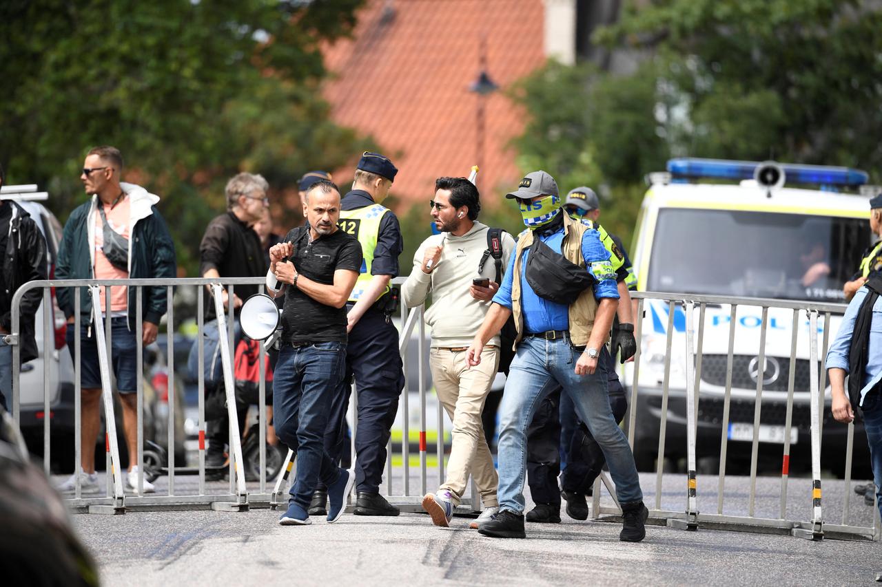Protestor Salwan Momika is escorted by police to a location outside the Iraqi  embassy, in Stockholm,