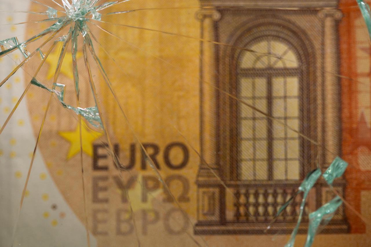 FILE PHOTO: Euro banknote is seen through broken glass in this illustration