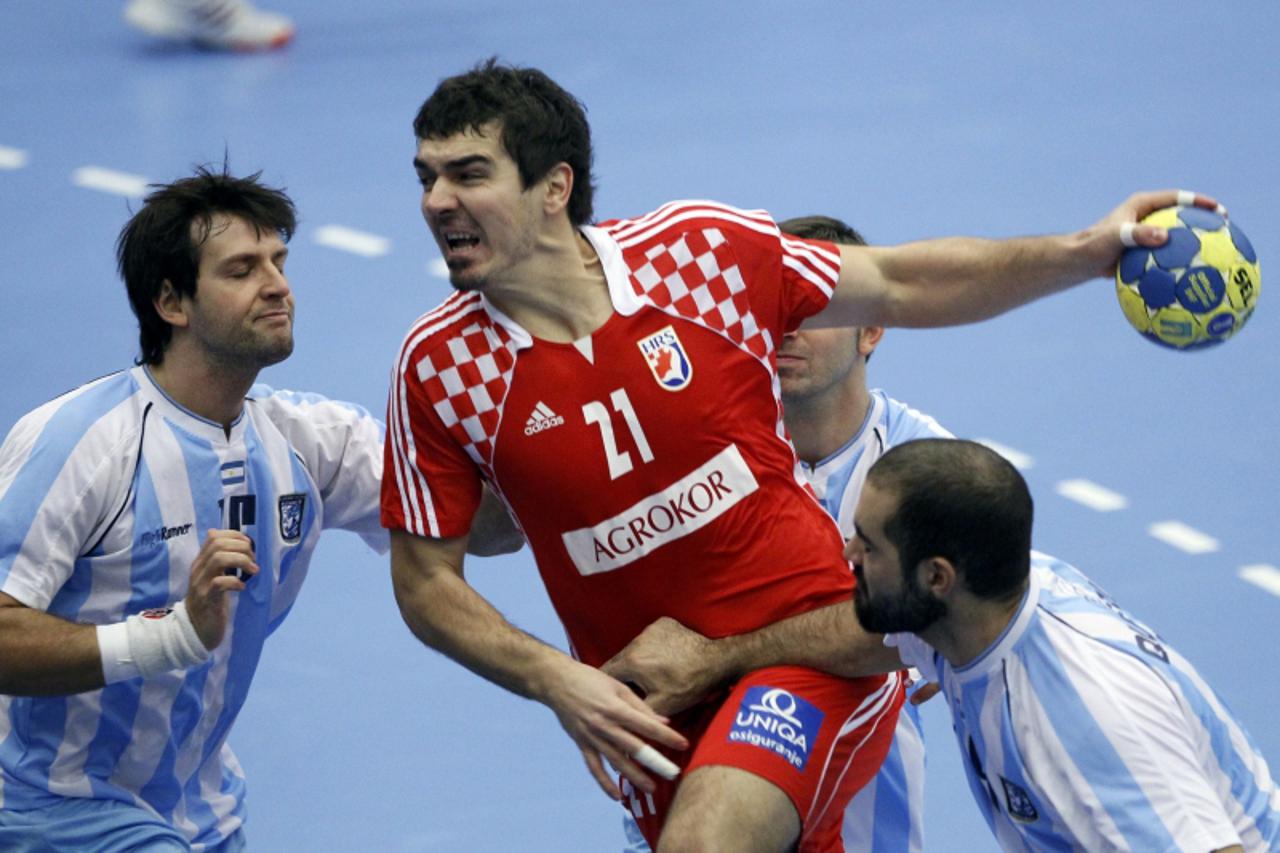 \'Croatia\'s Denis Buntic (C) is challenged by Argentina\'s Gonzalo Carou (L) and Leonardo Querin during their main round at the Men\'s Handball World Championship in in Lund January 22, 2011.  REUTER