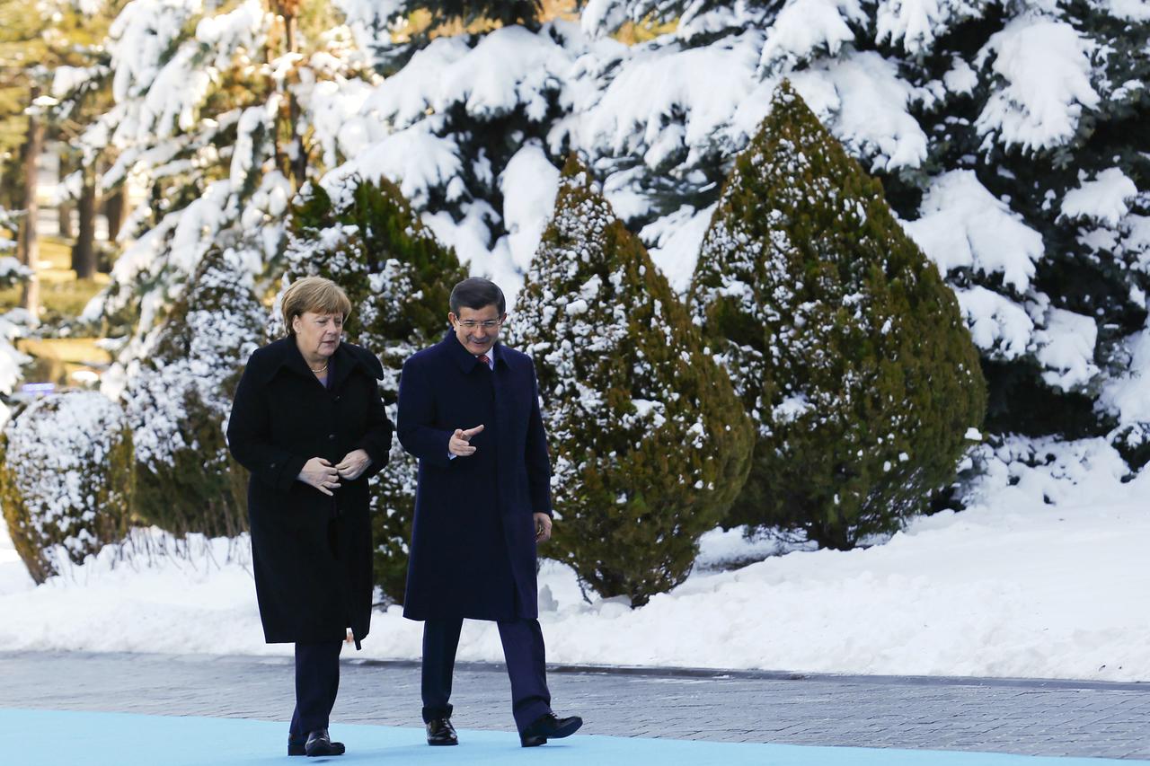 Turkish Prime Minister Ahmet Davutoglu (R) and German Chancellor Angela Merkel chat during a welcoming ceremony in Ankara, Turkey February 8, 2016.  REUTERS/Umit Bektas