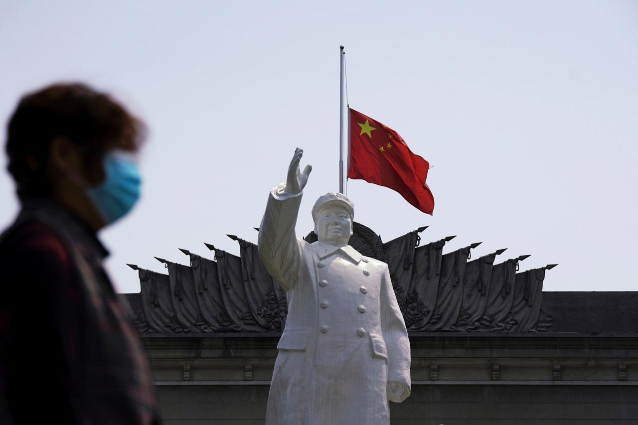 FILE PHOTO: The Chinese national flag flies at half-mast behind a statue of late Chinese chairman Mao Zedong in Wuhan