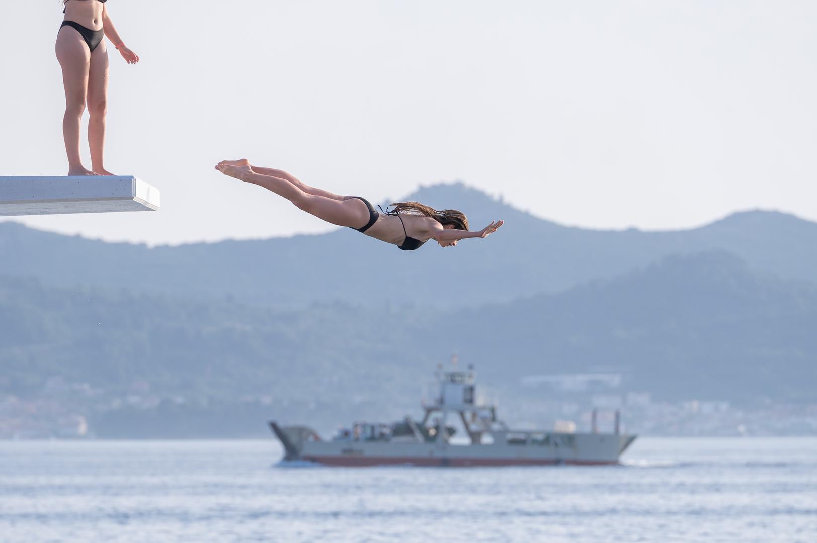 23.06.2023., Zadar -  Revijom zadarskih klubova vodenih sportova i zabavnim programom u petak je nakon višemjesecne obnove simbolicno otvorena betonska skakaonica na bazenu Kolovare. Podignuta je prije 67 godina i do danas je ostala jedina desetmetarska skakaonica na Jadranu s koje se skace u more, a ne u bazensku vodu. Photo: Dino Stanin/PIXSELL
