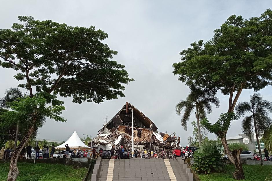 People look at the damaged governor of West Sulawesi province's office following an earthquake in Mamuju