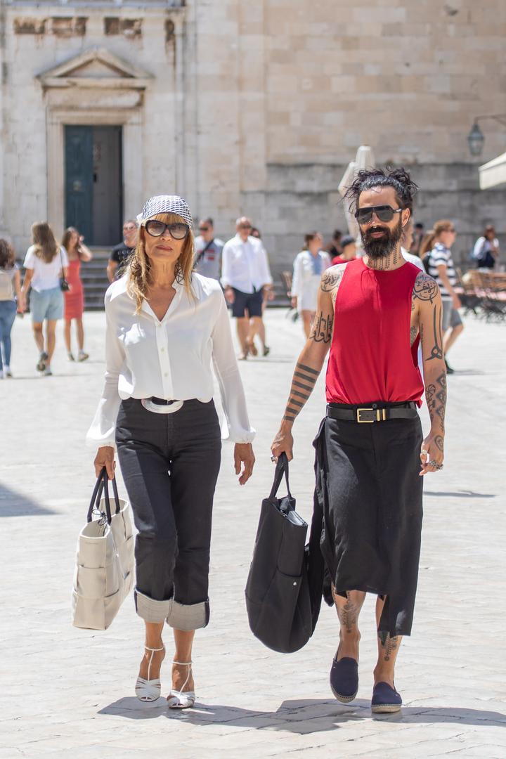 Dok je ona bila u bijeloj košulji i s maramom na glavi, on je nosio crvenu majicu bez rukava i s velikim prorezom sa strane te držao kosu u repu.