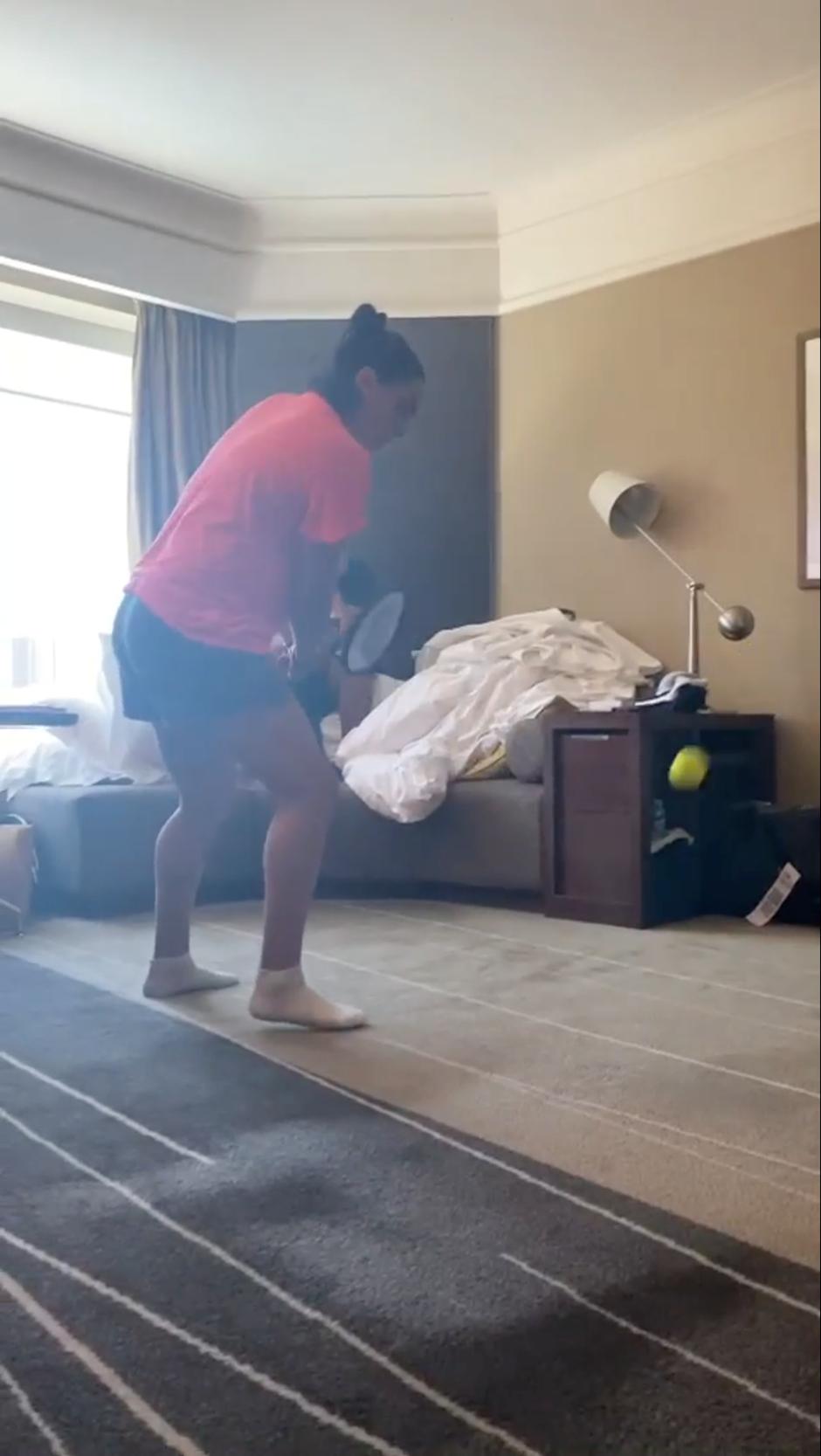 Tunisia's tennis player Ons Jabeurin hits a tennis ball towards a mattress leaning on a wall at a hotel room in Melbourne