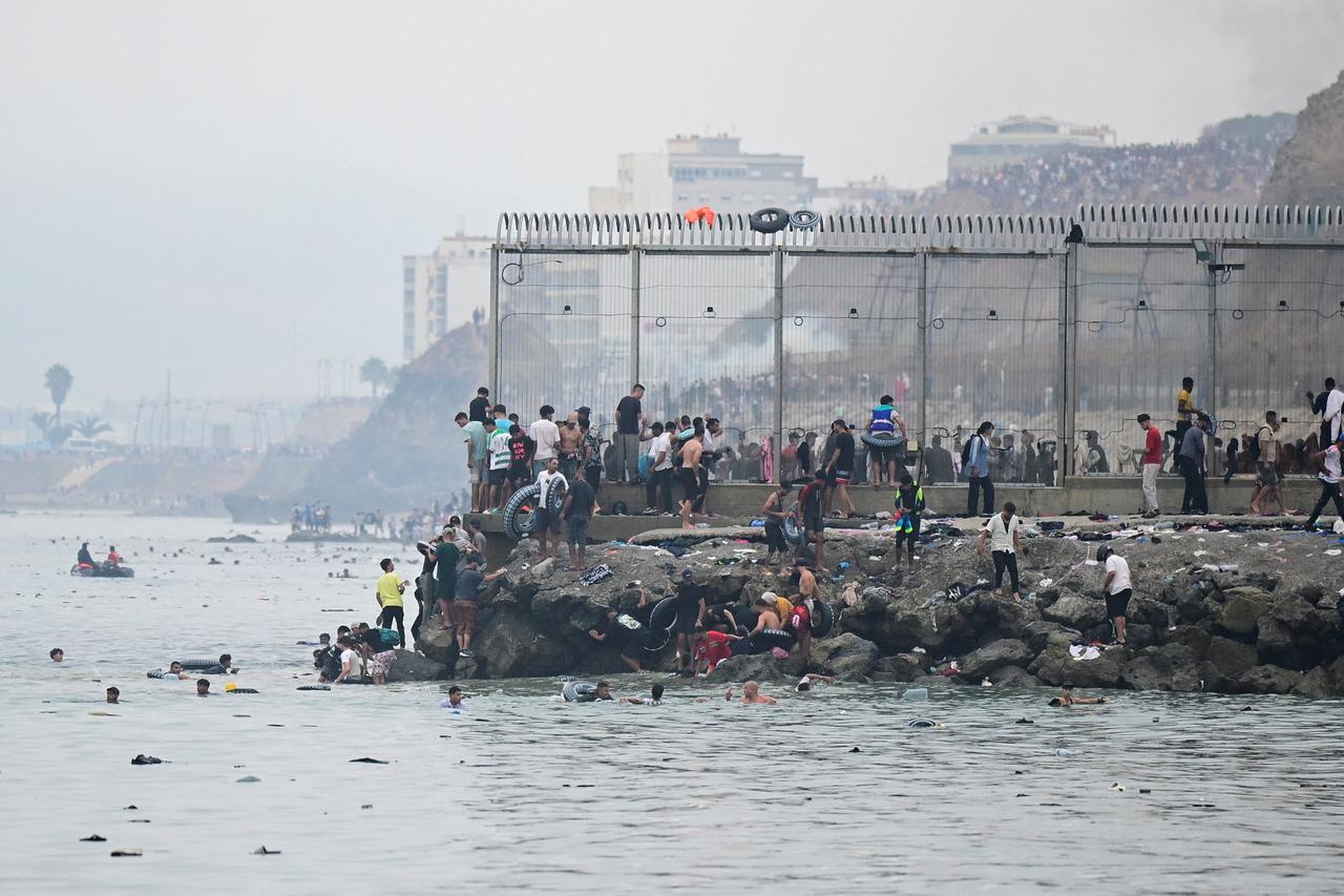 Migrants cross the border swimming through the sea, in Ceuta