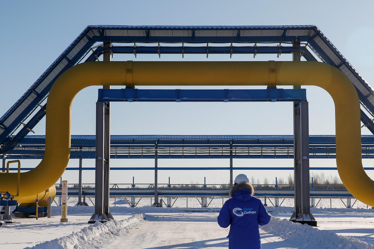 FILE PHOTO: An employee walks past a part of Gazprom's Power Of Siberia gas pipeline at the Atamanskaya compressor station outside the far eastern town of Svobodny