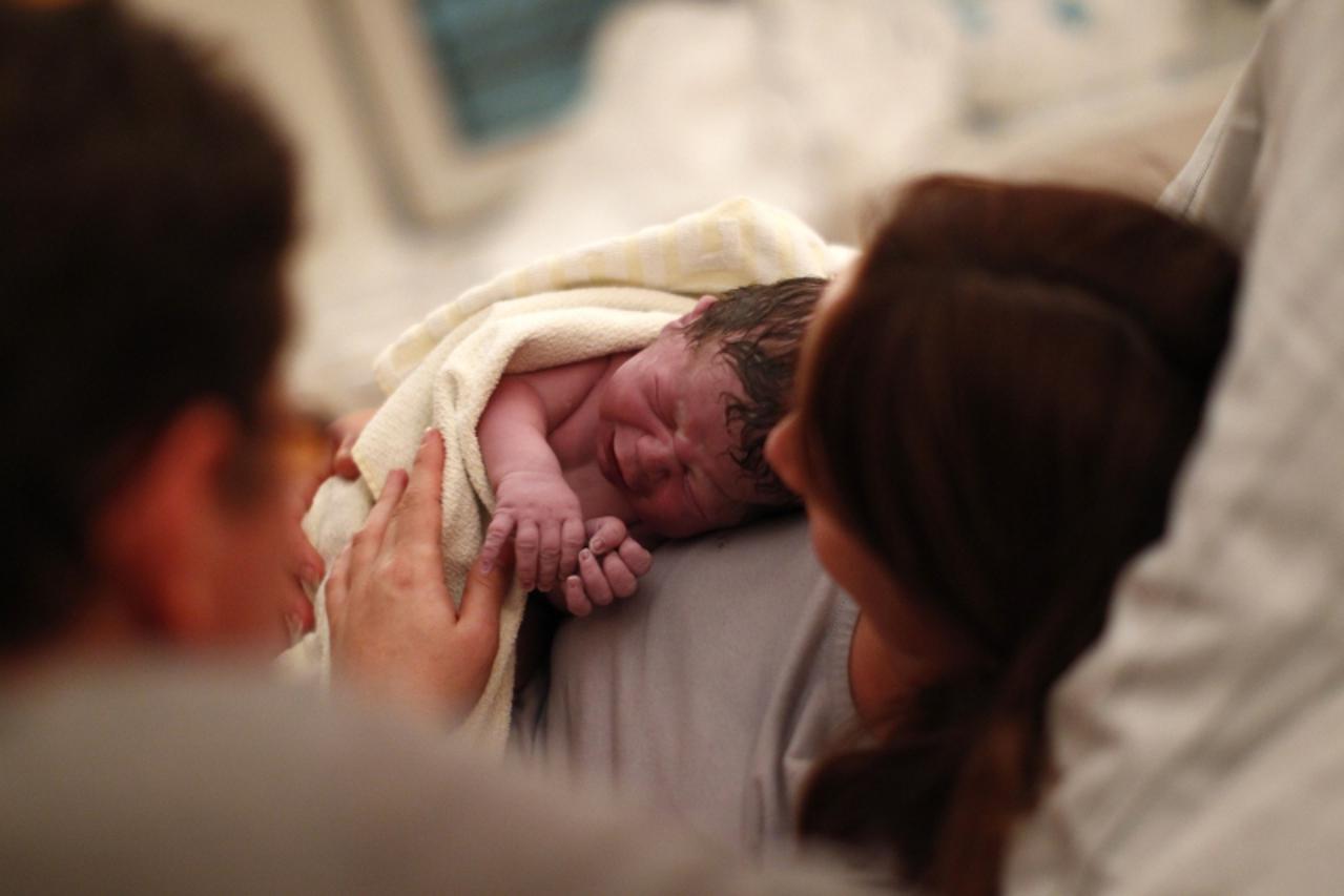 'Newborn Stefan Alexander Heinrich rests with mother Sabine Heinrich in a delivery room of Fuerstenfeldbruck hospital, southern Germany, January 12, 2013. Stefan was born at 3:47 on January 12, 2013, 