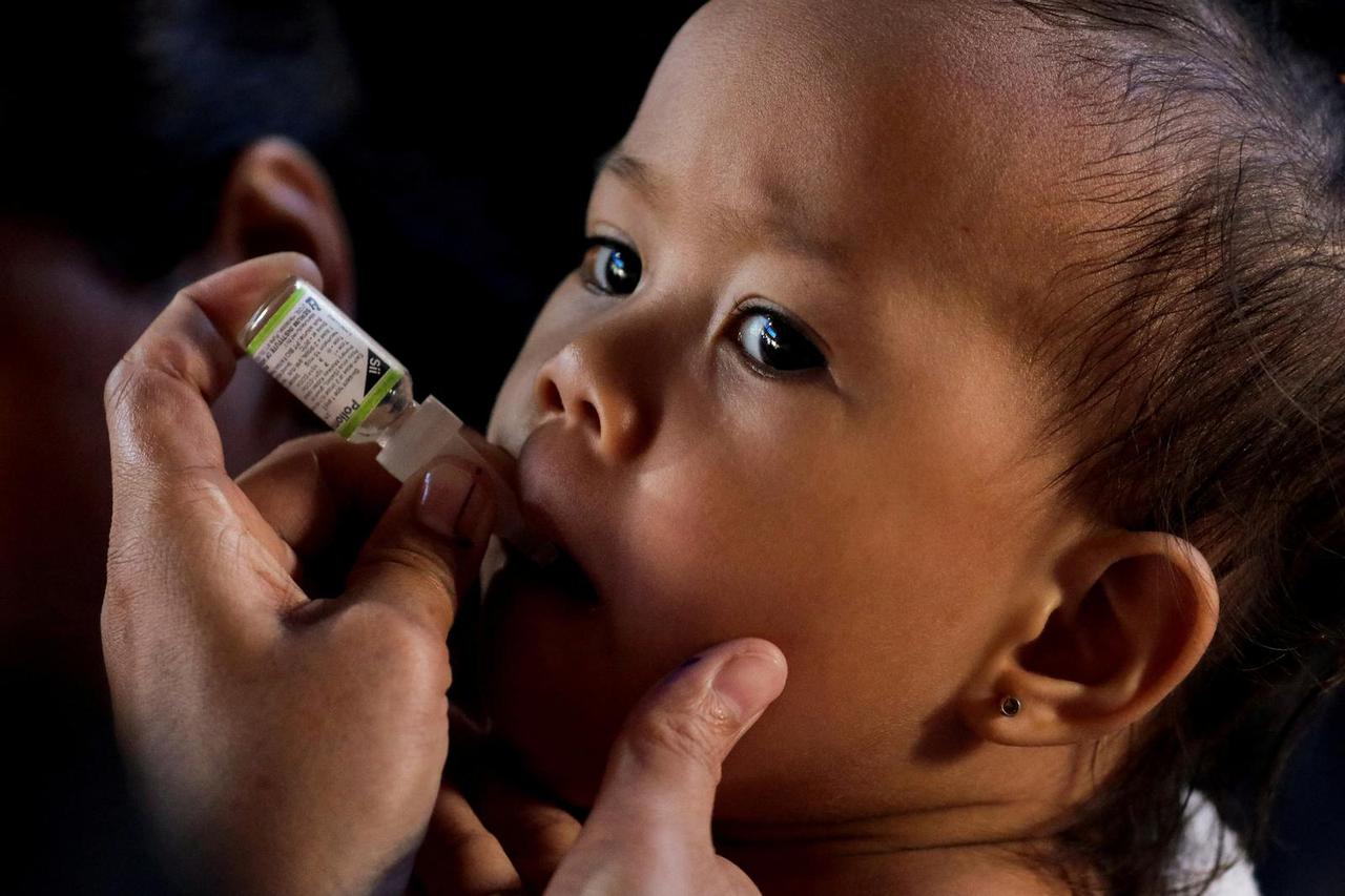 FILE PHOTO: A child receives free polio vaccine during a government-led mass vaccination program in Quezon City