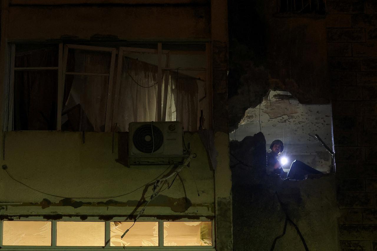 Emergency personnel inspect inside a damaged building, amid the U.S.-Israeli conflict with Iran,  Kiryat Shmona