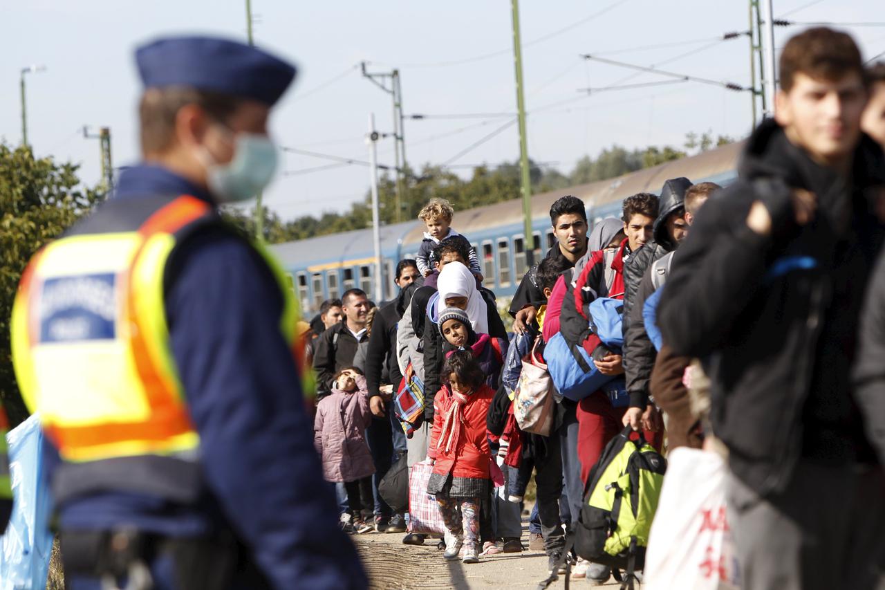 Migrants queue to board a train at the railway station in Zakany, Hungary October 1, 2015.  Hungary is ready to close its border with Croatia, except at border stations, to limit the flow of migrants from the Middle East, in a move similar to the closure 