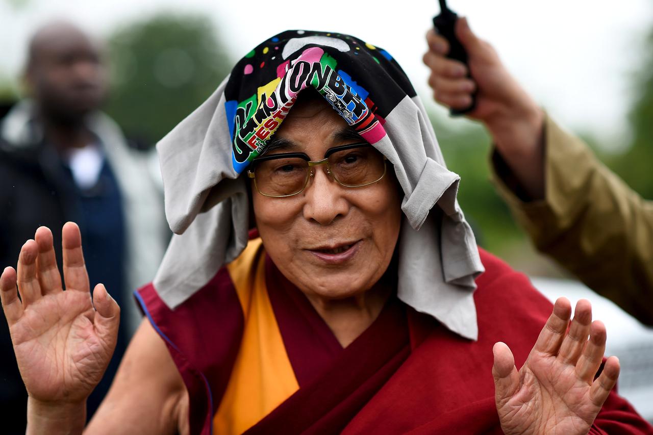 FILE PHOTO: The Dalai Lama greets well-wishers before addressing a crowd gathered at Worthy Farm in Somerset during the Glastonbury Festival