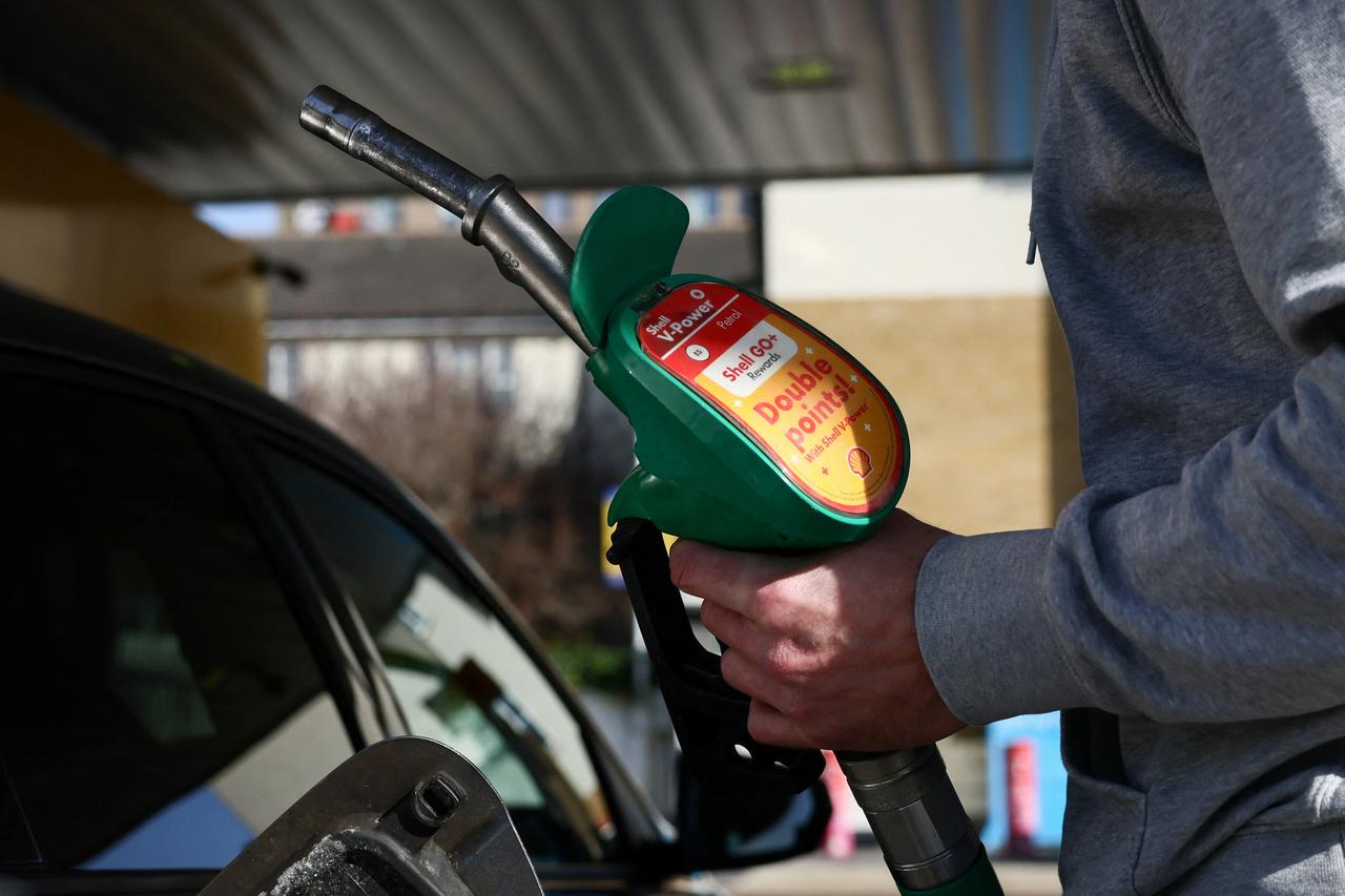 A motorist returns the petrol pump after filling their car with fuel at a petrol station, as the price of oil and gas has surged amid the conflict in the Middle East, in London