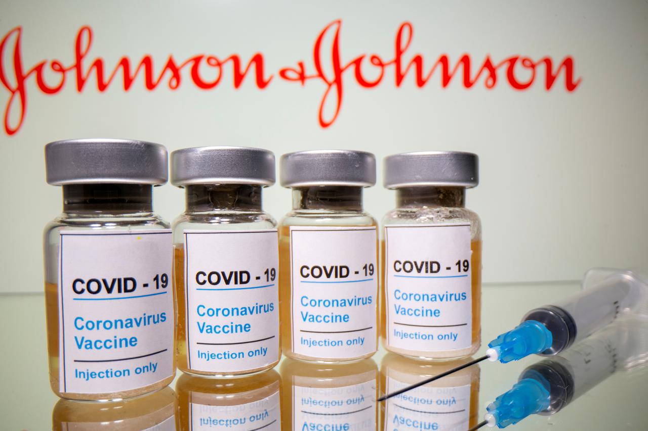 FILE PHOTO: FILE PHOTO: Vials and medical syringe are seen in front of J&J logo in this illustration