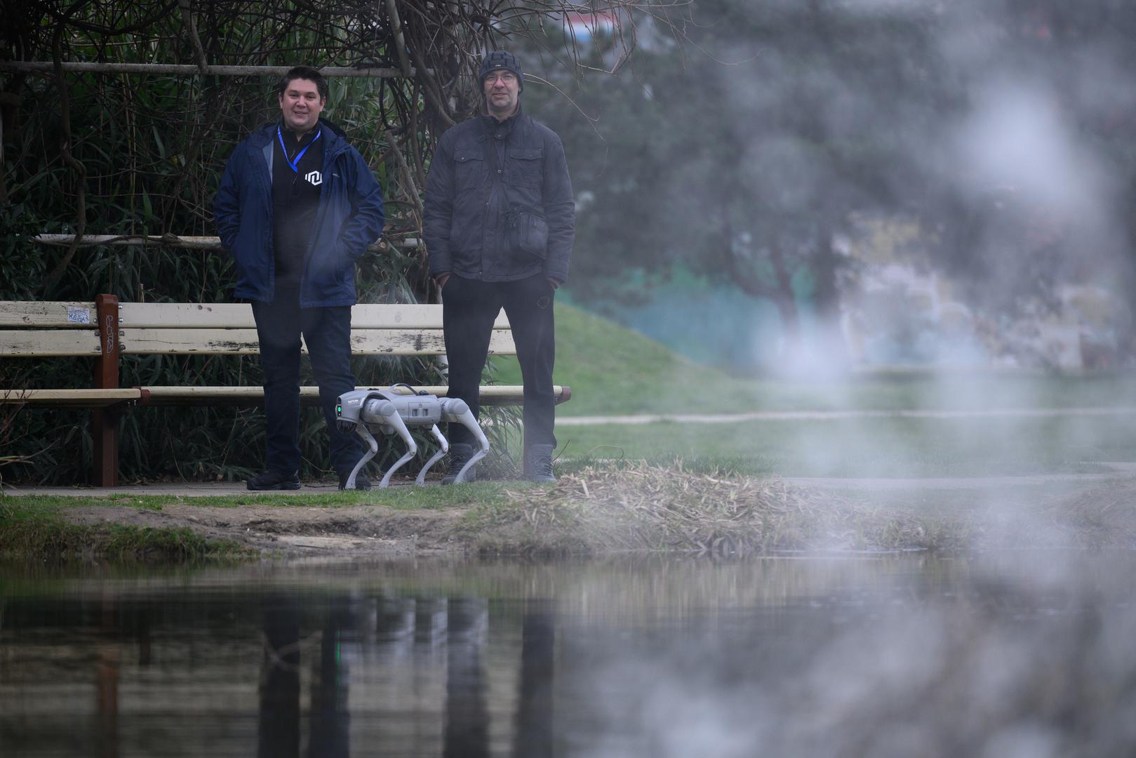 07.03.2024., Velika Gorica -  Milan Rajcevic, vlasnik i direktor tvrtke Notum Robotics sa suradnikom Ivanom Batinicem prosetao je Parkom dr. Franje Tudjmana u velikoj Gorici u drustvu robota psa. Za robota su podjednako bili zainteresirani prolaznici i njihovi ljubimci psi. Robot pas je komercijalni proizvod koji se radi po narudjbi, a ono sto je kod njega interesantno i unikatno su softverska rijesenja. Poanta je da ta platforma bude autonomna, bez ljudske intervencije i sa minimalnim odrzavanjem izvrsava zadatke prema svojem programu, da se snalazi u nepoznatim okolnostima, po nepoznatom terenu. Primjene su neogranicene, od sigurnosnih primjena, sluzbe spasavanja, nadzora te interakcije i edukacije. Puni se do 24 sata zbog tehnologije baterije i moze raditi do 3 sata, a trcati moze brzinom do 20 km/h. Trenutno nije vodootporan ali s vremenom moze postati i vodootporan i vatrootporan za siri spektar primjena. Milan Rajcevic, Ivan Batinic.
 Photo: Davor Puklavec/PIXSELL