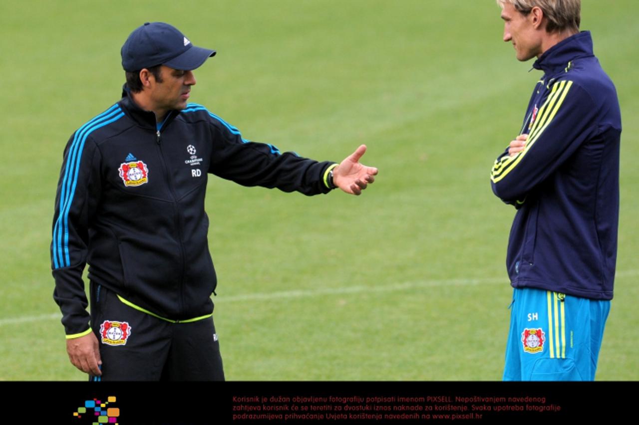 'Leverkusen\'s headcoach Robin Dutt (L) speaks to coach-trainee Sami Hyypia during a training session of his team in Leverkusen, Germany, 27 September 2011. Bayer 04 Leverkusen faces Belgian club KRC 