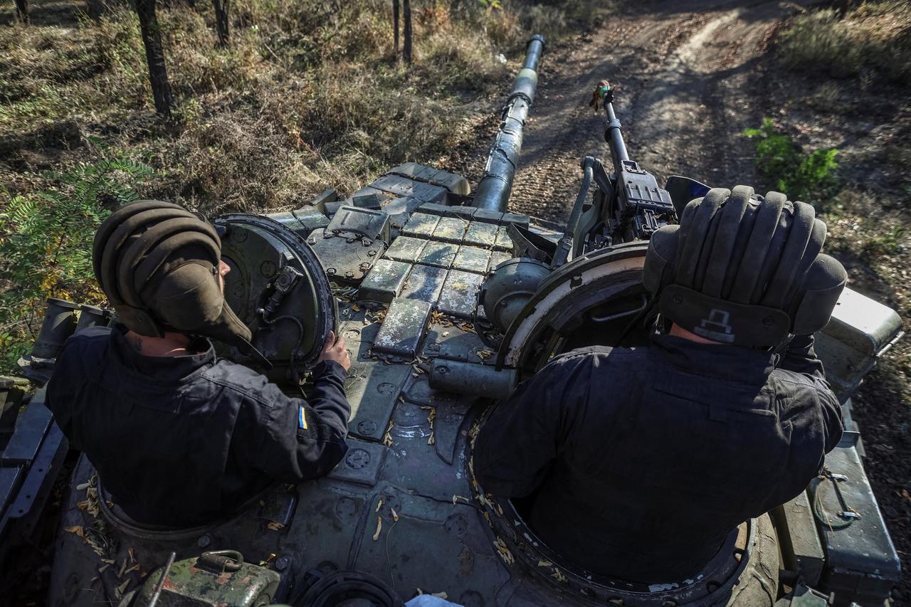 Ukrainian servicemen ride a tank in Donetsk region