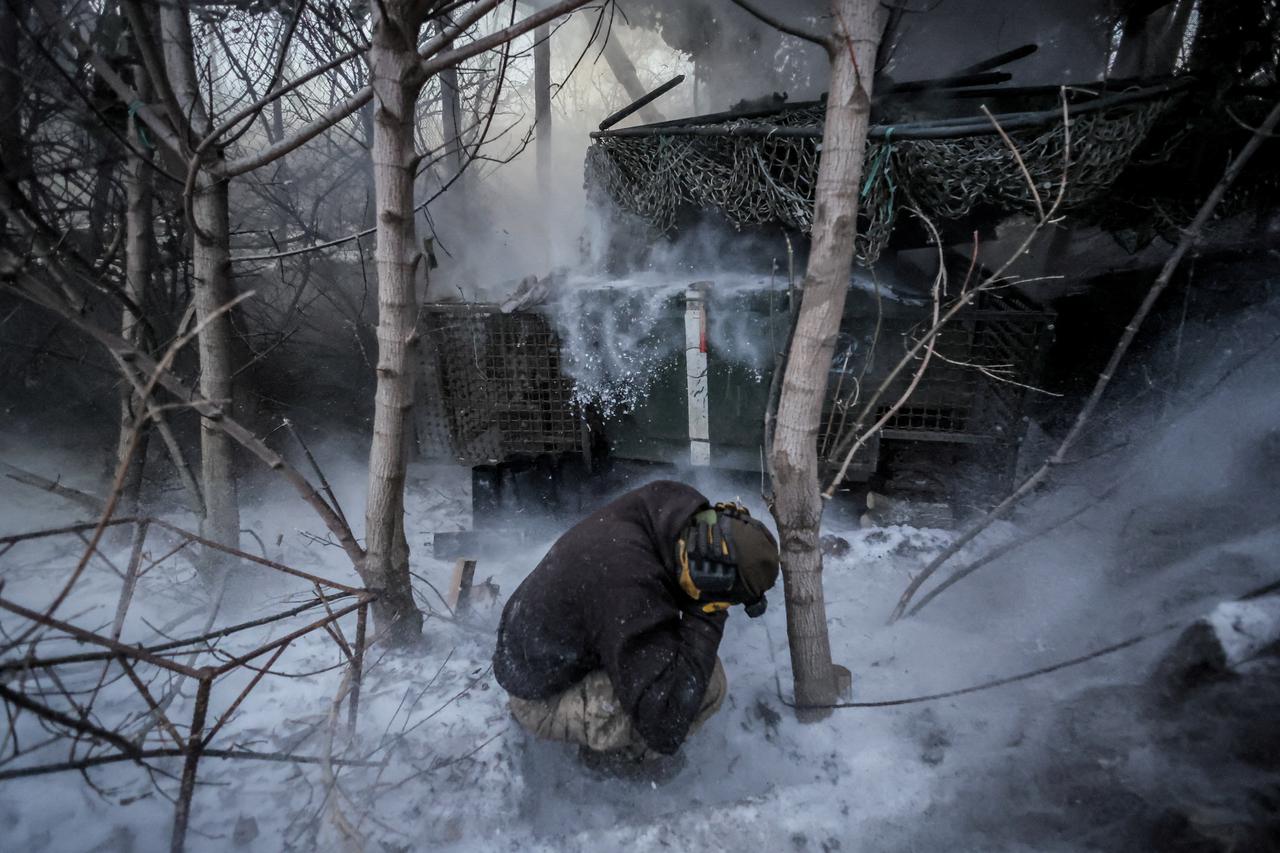A serviceman of the Ukrainian Armed Forces reacts after firing a 2S1 Gvozdika self-propelled howitzer towards Russian troops near the frontline town of Chasiv Yar